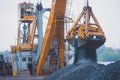 Yellow heavy excavator and bulldozer excavating sand and working during road works, unloading sand and road metal