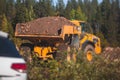 Yellow heavy excavator and dump tip truck tipper excavating sand and working during road works, unloading sand during construction Royalty Free Stock Photo