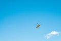 A yellow helicopter flying in the blue sky Royalty Free Stock Photo