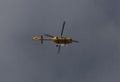 Yellow helicopter flying in the blue sky Royalty Free Stock Photo