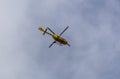 Yellow helicopter flying in the blue sky Royalty Free Stock Photo