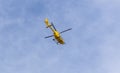 Yellow helicopter flying in the blue sky Royalty Free Stock Photo