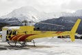 A yellow helicopter in the snowy alps switzerland in winter