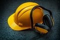 Yellow helmet and earphones on blackbackground Royalty Free Stock Photo