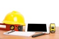 Yellow helmet and tablet tools on wooden table