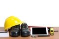 yellow helmet and tablet tools on wooden table