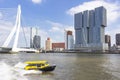 A yellow high-speed water taxi with in the background the Erasmus bridge and the Hotel nhow Rotterdam