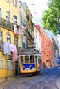 Yellow historic tram in lisbon driving through the old town of alfama