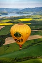 Yellow hot-air balloon and beautiful green fields and lake under in Liptov area, Slovakia Royalty Free Stock Photo