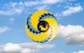 Yellow hot air balloon is flying in the blue sky. Royalty Free Stock Photo