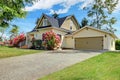 Yellow house exterior with spring blooming rhododendron Royalty Free Stock Photo