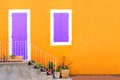 Yellow house front with purple shuttered door and window