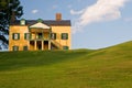 Yellow house on grassy hill