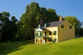 Yellow house on grassy hill