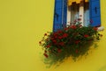 yellow house with red geraniums on the island of Burano near Venice in Italy Royalty Free Stock Photo