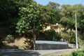 Yellow house with terrace built in Caribbean style surrounded by palm trees situated near the road.