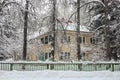 Yellow house among trees in winter