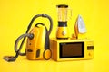 Yellow household appliances on yellow background. Set of home technics