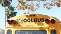 Yellow iconic school bus in Los Angeles, California USA. Classic truck for students back view. Vehicle stoplights for safety of