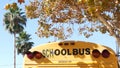 Yellow iconic school bus in Los Angeles, California USA. Classic truck for students back view. Vehicle stoplights for safety of