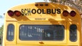 Yellow iconic school bus in Los Angeles, California USA. Classic truck for students back view. Vehicle stoplights for safety of