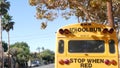 Yellow iconic school bus in Los Angeles, California USA. Classic truck for students back view. Vehicle stoplights for safety of Royalty Free Stock Photo