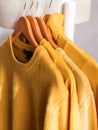 Yellow illuminated color winter sweaters on hangers