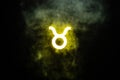 Yellow illuminated Taurus zodiac sign with smoke