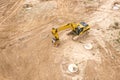 Yellow industrial excavator working on construction site. drone view Royalty Free Stock Photo