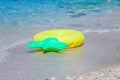 Yellow inflatable paddling circle in shape of pineapple in the sand near the sea.ring floating near the beach,Colorful