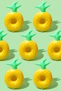 Yellow inflatable pineapples on a green background