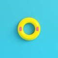 Yellow inflatable ring on bright blue background in pastel color