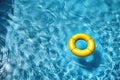 A yellow inflatable ring is floating in a pool of water Royalty Free Stock Photo