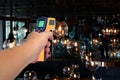 Yellow Infrared thermometer gun in hand used to measure temperature