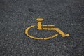 Yellow international handicapped parking symbol on asphalt road with copy space. Empty spot with handicapped parking symbol.