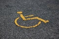 Yellow international handicapped parking symbol on asphalt road with copy space. Empty spot with handicapped parking symbol.