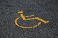 Yellow international handicapped parking symbol on asphalt road with copy space. Empty spot with handicapped parking symbol.