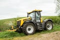 Yellow JCB Fastrac tractor parked by hedge