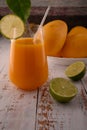 Yellow juice closeup with lime slice on white vintage wooden desktop Royalty Free Stock Photo
