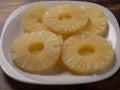 Yellow juicy pineapple rings on a white plate close up. Royalty Free Stock Photo