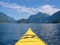 A yellow kayak head points to the beautiful mountains and ocean. Royalty Free Stock Photo