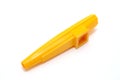 A yellow Kazoo made of plastic isolated on white background.