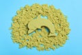 Yellow kinetic sand on light blue background, flat lay Royalty Free Stock Photo
