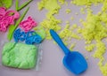 Yellow kinetic sand and molds on a pink table