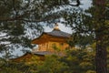 Yellow Kinkaku-ji or Rokuon-ji Buddhist temple in Kyoto Japan behind vegetation Royalty Free Stock Photo