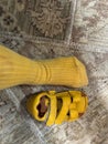Yellow sock and sandal on patterned carpet Royalty Free Stock Photo