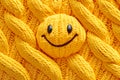 A yellow knitted sun with a smiley face on it Royalty Free Stock Photo