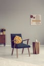 Knot pillow on trendy vintage armchair in empty room
