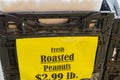 Yellow label for fresh roasted peanuts on black plastic crater at farmer market in USA Royalty Free Stock Photo