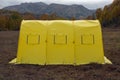 Yellow large basecamp tent on colorful mountains background